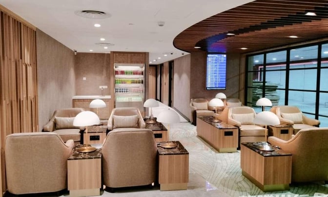 The seating area in the Travel Club Lounge at Kota Kinabalu International Airport features armchairs with side tables and individual lamps.