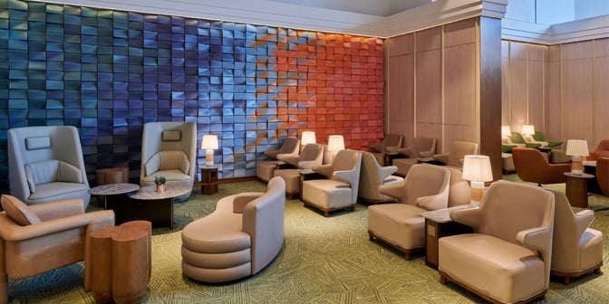 The seating area in Plaza Premium First Lounge at Kuala Lumpur International Airport features comfortable chairs and tables with individual lamps.