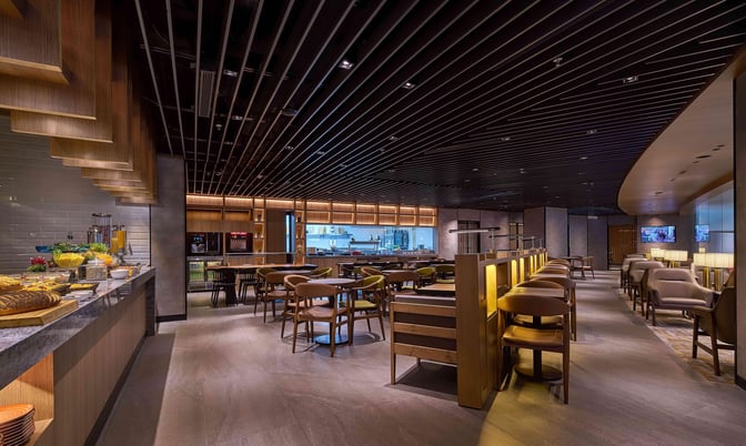 The Plaza Premium Lounge at Kuala Lumpur International Airport features a self-serve food area with seating and a variety of refreshments.