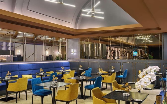 The Sky Suite Airport Lounge at Kuala Lumpur International Airport features a seating area with tables and chairs for dining and relaxation.