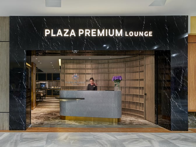 The entrance to Plaza Premium Lounge at Langkawi International Airport features a reception desk with a staff member ready to assist.