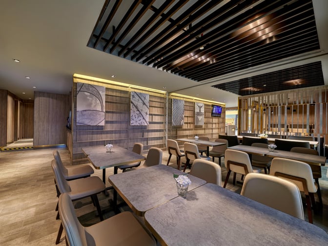 The seating area in Plaza Premium Lounge at Langkawi International Airport features tables and chairs for dining and relaxation.