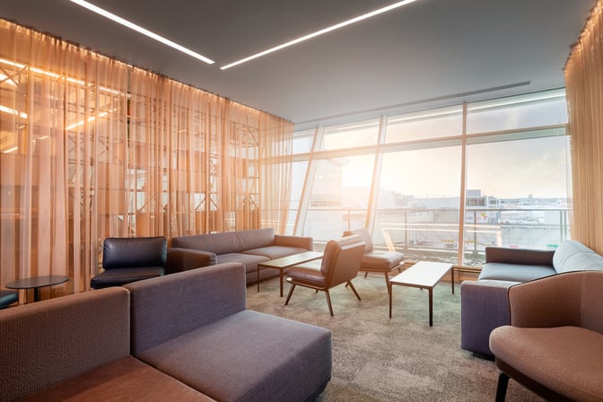 The seating area in Club Aspire Lounge at London Gatwick Airport features comfortable chairs and sofas with views of the tarmac.