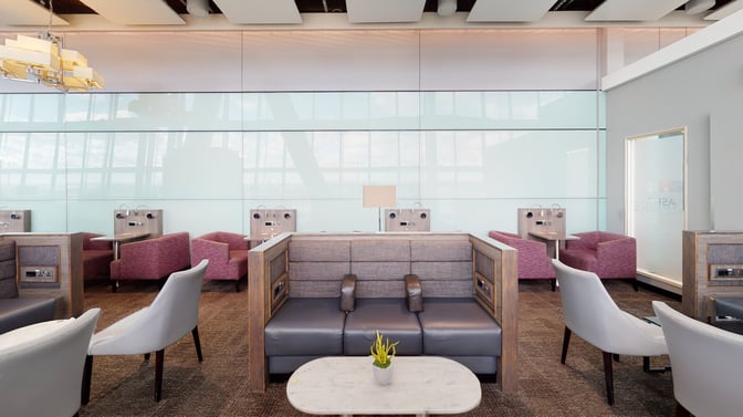 The Club Aspire Lounge at London Heathrow features booth seating with individual power outlets and small tables for travelers.