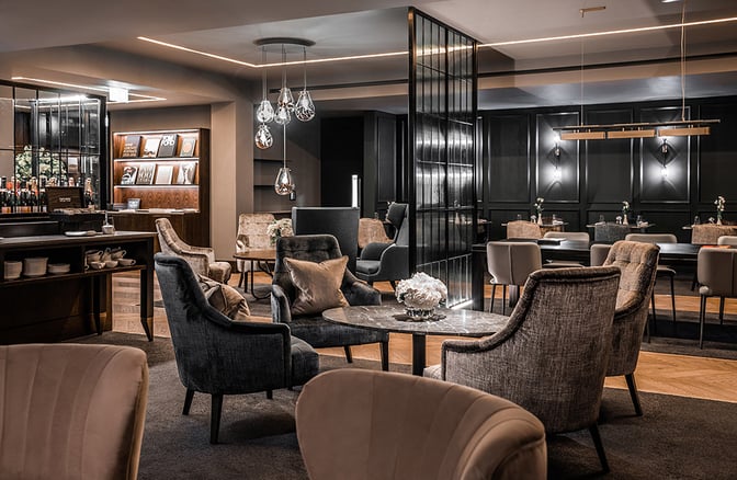 The No1 Lounge at London Luton Airport features comfortable seating areas with tables, offering a relaxing space for travelers.