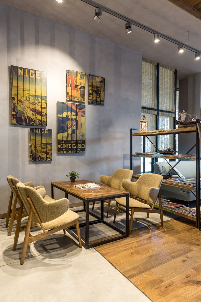 The seating area in the Primeclass Lounge (Domestic) at Milas–Bodrum Airport features a table with chairs and decorative wall art.