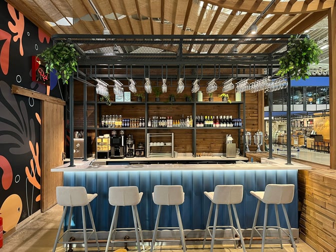 The Primeclass Lounge bar at Milas–Bodrum Airport (Domestic) offers a selection of beverages with counter seating and overhead glass storage.