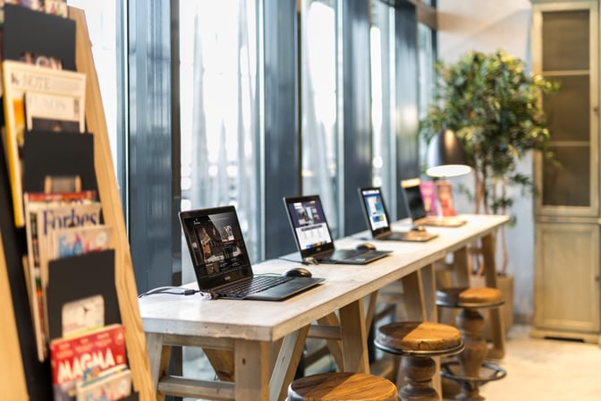 The Primeclass Lounge at Milas–Bodrum Airport (Domestic) features a work area with laptops on a long table and nearby magazine rack.