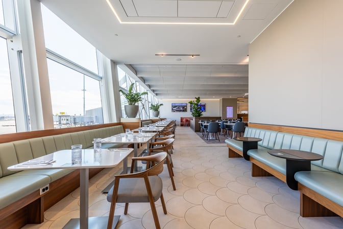 Booth seating at the Aspire International Lounge in Montreal offers dining spaces with views of the airport tarmac.