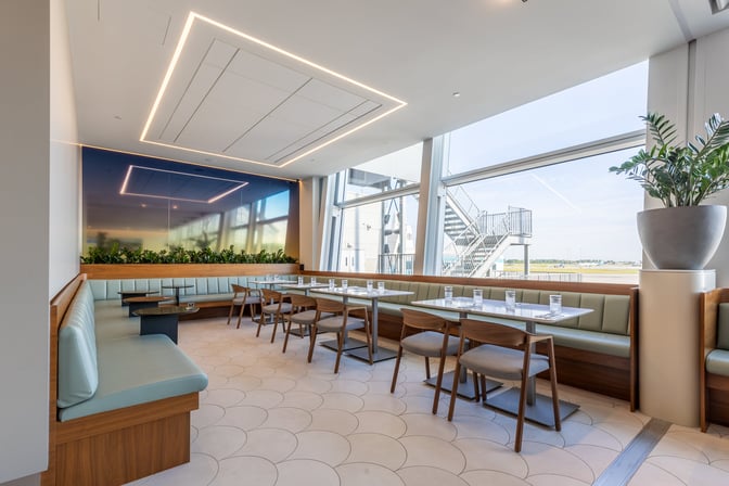 Booth seating at Aspire International Lounge in Montreal offers semi-private dining with views of the airport tarmac.