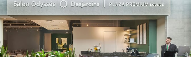 The entrance to the Desjardins Odyssey Lounge at Montreal-Trudeau International Airport features a reception desk and bar seating area.