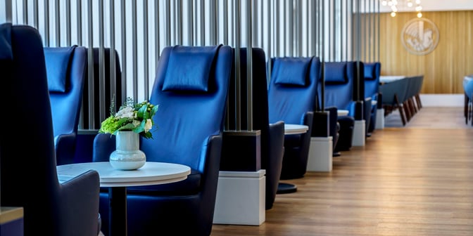 The seating area in the Air France Lounge at Montreal-Trudeau Airport features individual chairs with small tables for passenger comfort.