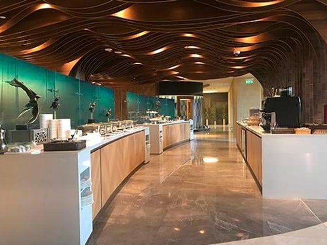 Self-serve food stations at Primeclass Lounge in Muscat International Airport offer a variety of dining options for travelers.