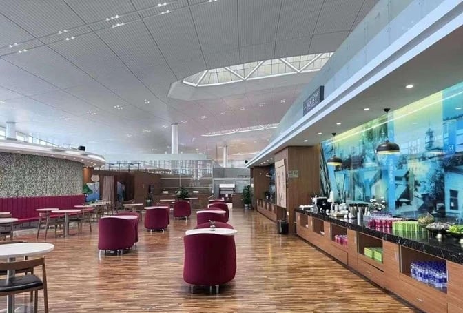 The V6 Business Lounge at Nanjing Lukou International Airport features a spacious seating area and a self-serve beverage station.