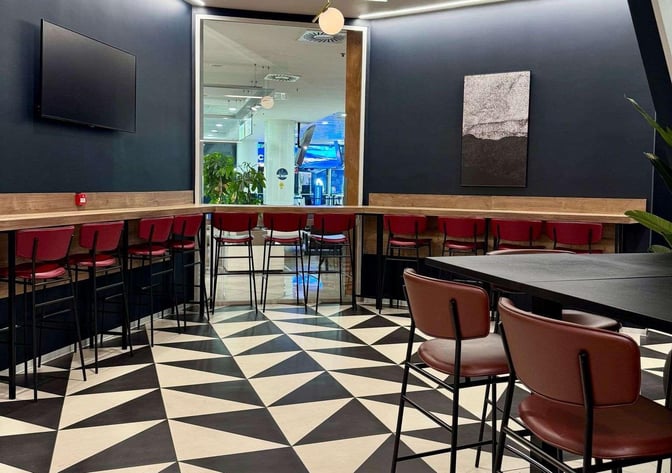 High-top seating in the Pearl Lounge at Naples International Airport offers a space for dining or working with a view of the terminal.