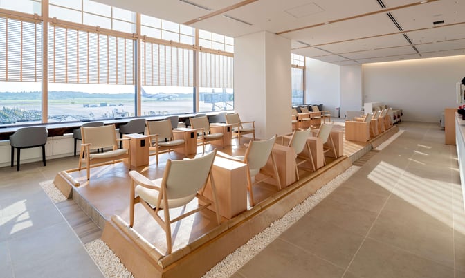 The seating area in the IASS Superior Lounge at Narita International Airport offers elevated chairs with views of the runway.