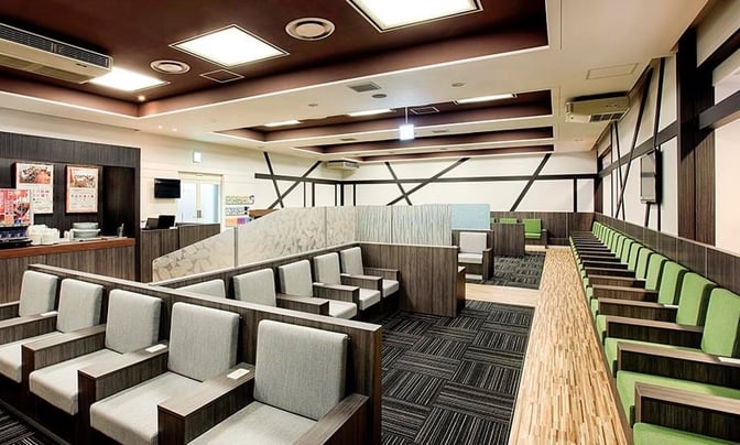 The IASS Executive Lounge 2 at Narita International Airport features a seating area with individual chairs and a self-serve beverage station.