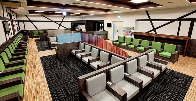 The IASS Executive Lounge 2 at Narita International Airport features spacious seating areas with individual chairs and a self-serve beverage station.