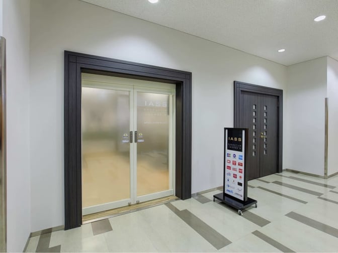 The entrance to the IASS Executive Lounge 2 at Narita International Airport features sliding doors and a sign displaying partner logos.