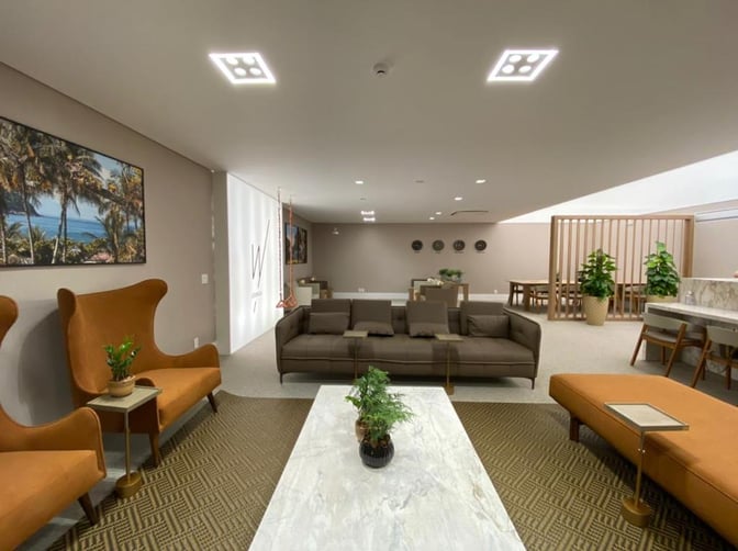 The W Lounge at Navegantes Airport features a seating area with sofas, armchairs, and tables for passenger relaxation.