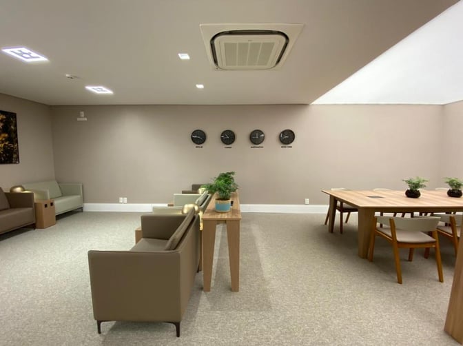 The seating area in W Lounge Navegantes features armchairs and tables with wall clocks displaying different time zones.