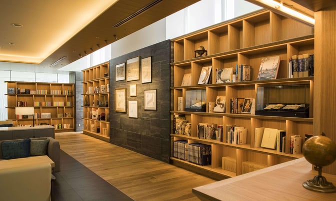 The CAFÉ SKY LIBRARY at New Chitose Airport features bookshelves filled with books and seating areas for relaxation and reading.