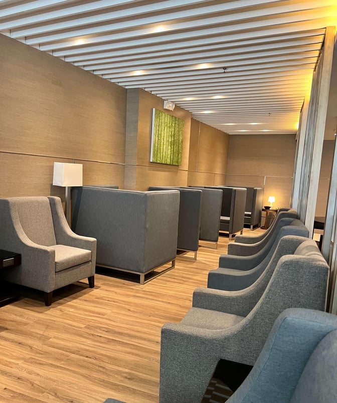 The seating area in Ninoy Aquino International Airport's lounge features individual armchairs and semi-private booths for passenger comfort.