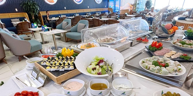 The First Lounge by Bamboo Airways at Noi Bai International Airport features a self-serve food area with salads, sushi, and cold cuts.