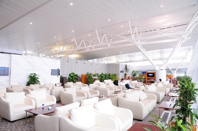 The ACV Business Lounge at Noi Bai International Airport features spacious seating with armchairs and tables, offering a comfortable waiting area.