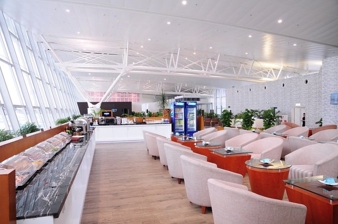 The ACV Business Lounge at Noi Bai International Airport features a self-serve food area and comfortable seating with tables.