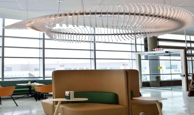 Booth seating in the Escape Lounge at Northwest Arkansas Regional Airport offers semi-private spaces with tables and airport views.