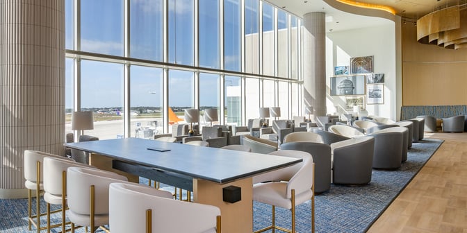The Plaza Premium Lounge at Orlando International Airport features spacious seating with airport views through large windows, offering a relaxing environment.