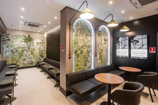 The W Café Lounge Palmas features seating with small tables and wall art, providing a comfortable waiting area at Brigadeiro Lysias Rodrigues Airport.