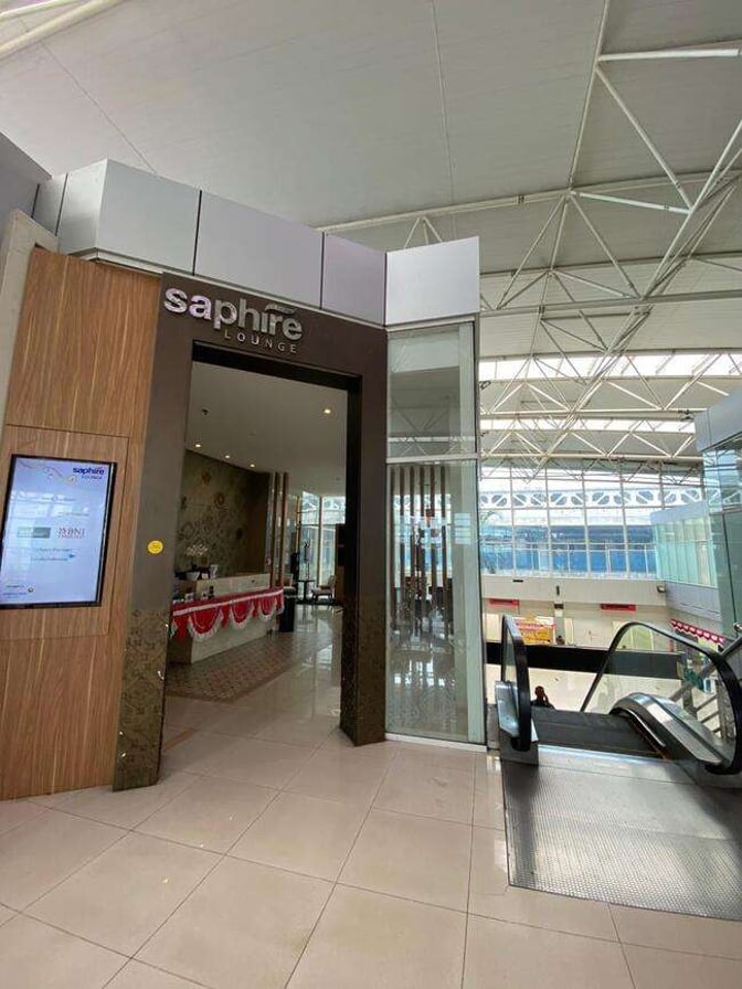 The entrance to the Saphire Lounge at Depati Amir Airport features a reception area and is located near an escalator.