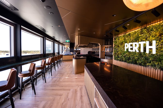 The International Aspire Lounge at Perth Airport features counter seating with large windows offering views of the runway.