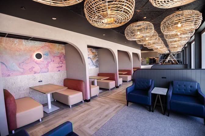 Booth seating in the International Aspire Lounge at Perth Airport offers semi-private dining spaces with tables and cushioned benches.