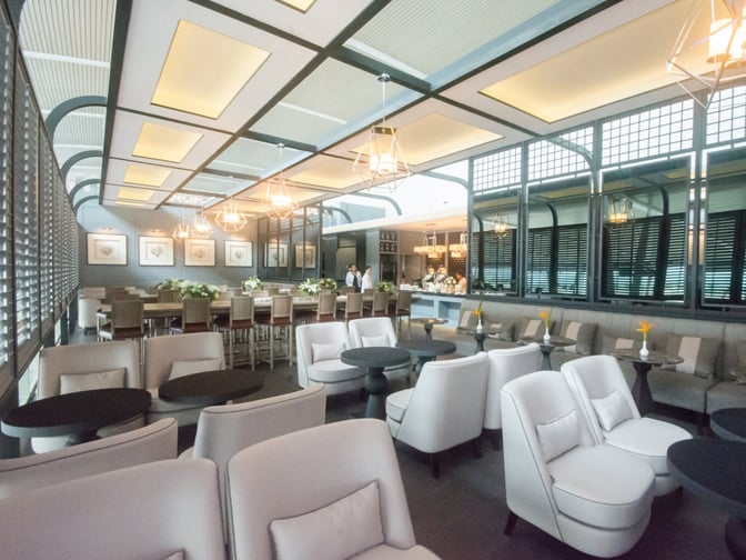The Coral Executive Lounge at Phuket International Airport features a spacious seating area with tables, chairs, and a buffet counter.