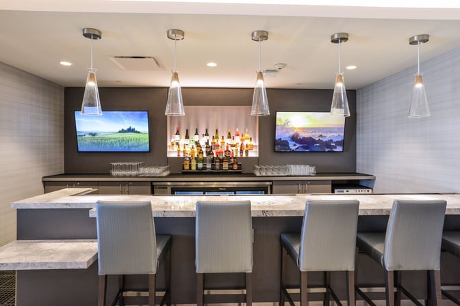 The Club PIT at Pittsburgh International Airport features a bar with a selection of spirits and seating for guests.