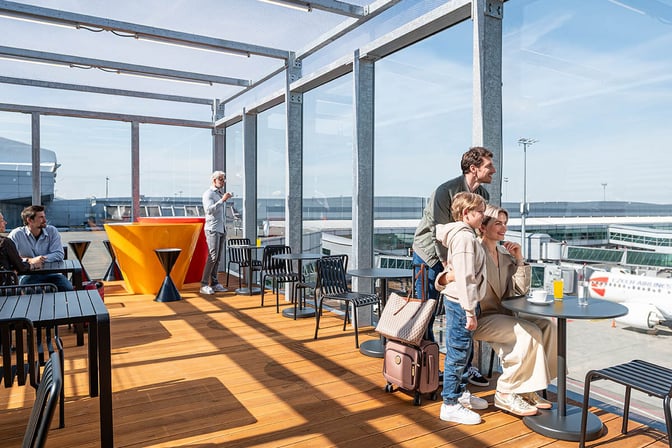 The Mastercard Lounge at Prague Vaclav Havel Airport features an outdoor seating area with tables, chairs, and views of the tarmac.