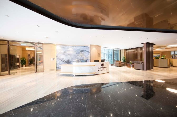 The Plaza Premium Lounge entrance at Qingdao Liuting International Airport features a reception desk and seating area for arriving guests.