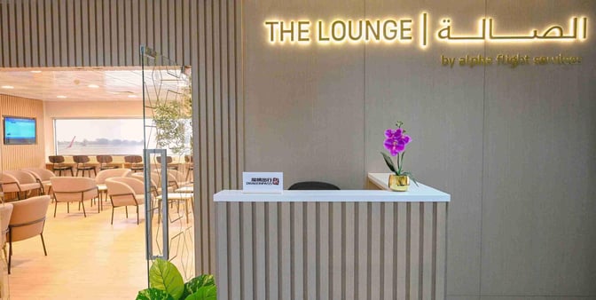 The entrance to The Lounge at Ras Al Khaimah International Airport features a reception desk and visible seating area with airport views.