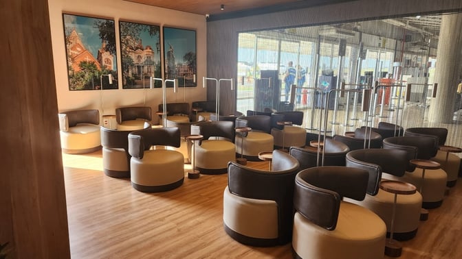 The seating area at W Lounge Ribeirão features circular chairs with individual tables, offering a comfortable space for travelers.
