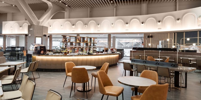 The Plaza Premium Lounge at Leonardo da Vinci-Fiumicino Airport features a central bar with seating and a variety of refreshments.