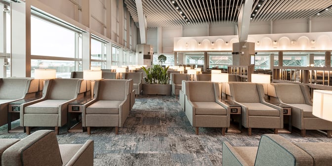 The seating area at Plaza Premium Lounge in Fiumicino Airport features comfortable chairs with individual lamps and power outlets.