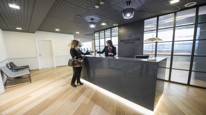 The reception area of the Prima Vista Lounge at Leonardo da Vinci-Fiumicino Airport features a check-in counter and seating.