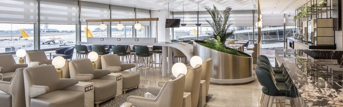 The Plaza Premium Bosphorus Lounge at Sabiha Gokcen International Airport features comfortable seating with tarmac views and a bar area for refreshments.
