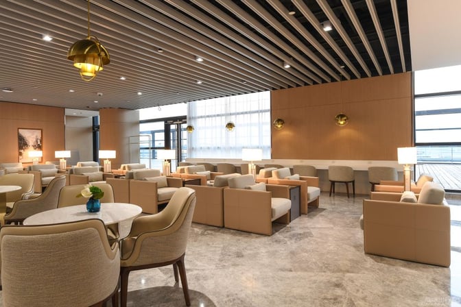 The seating area in No. 190 VIP Lounge at Shanghai Pudong International Airport features armchairs and tables with ample natural light.