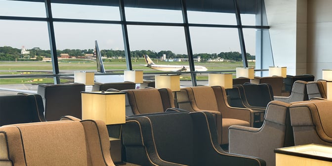 Seating at Plaza Premium Lounge in Singapore Changi Airport offers comfortable chairs with individual lamps and views of the runway.
