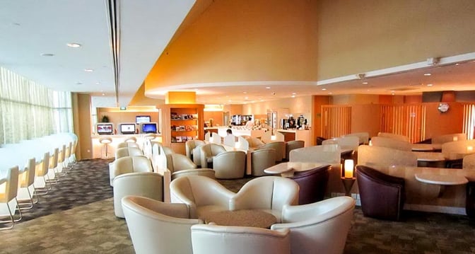 The SATS Premier Lounge at Singapore Changi Airport features comfortable seating, a self-serve beverage area, and computer workstations for travelers.