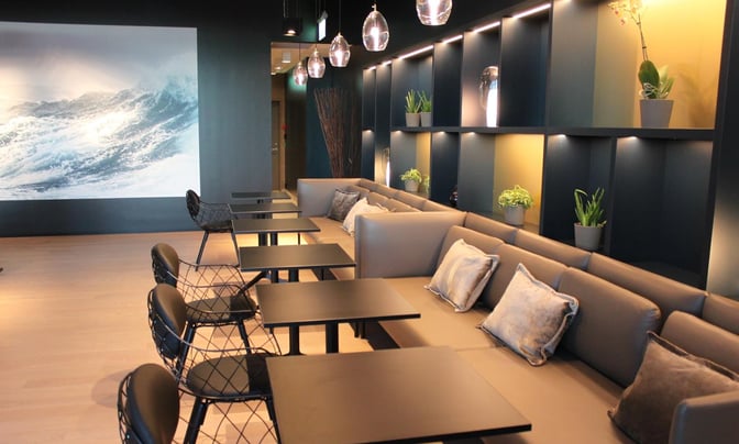 The North Sea Lounge at Stavanger Airport features booth seating with tables and decorative shelving, providing a comfortable waiting area.